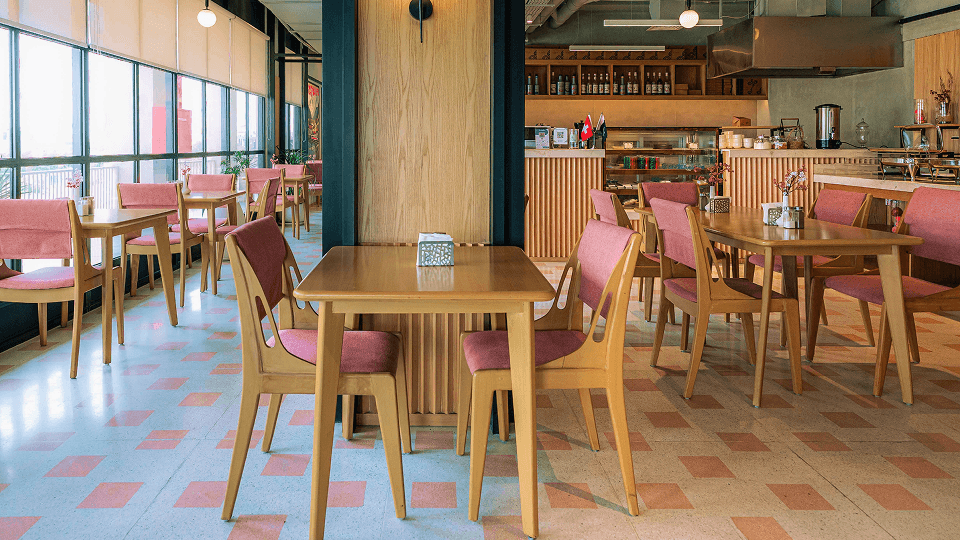 The bright Alpirious dining room with pink chairs and an open kitchen