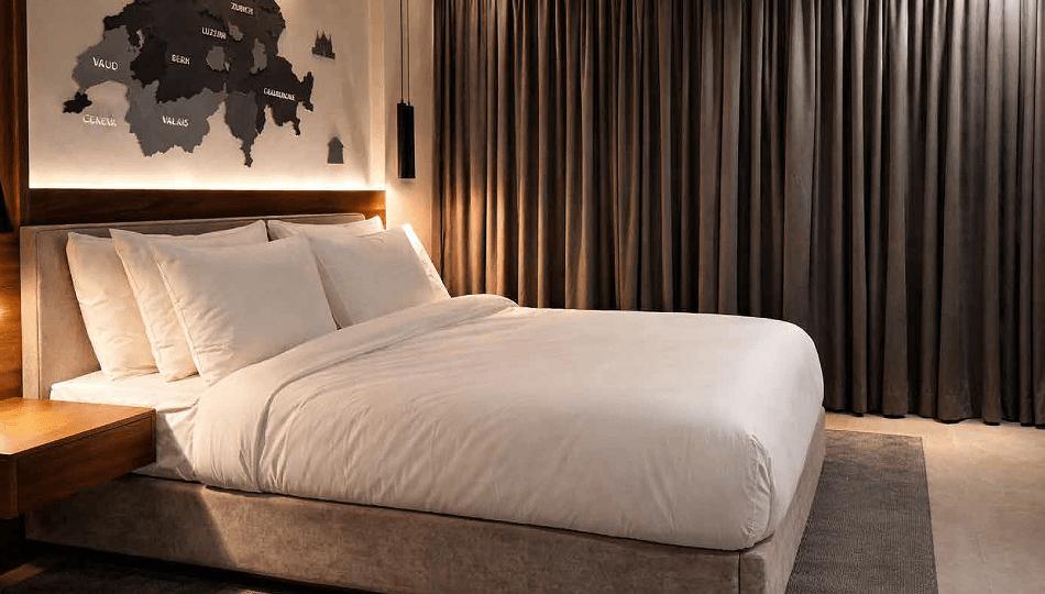 A contemporary suite with a Swiss map headboard and soft lighting