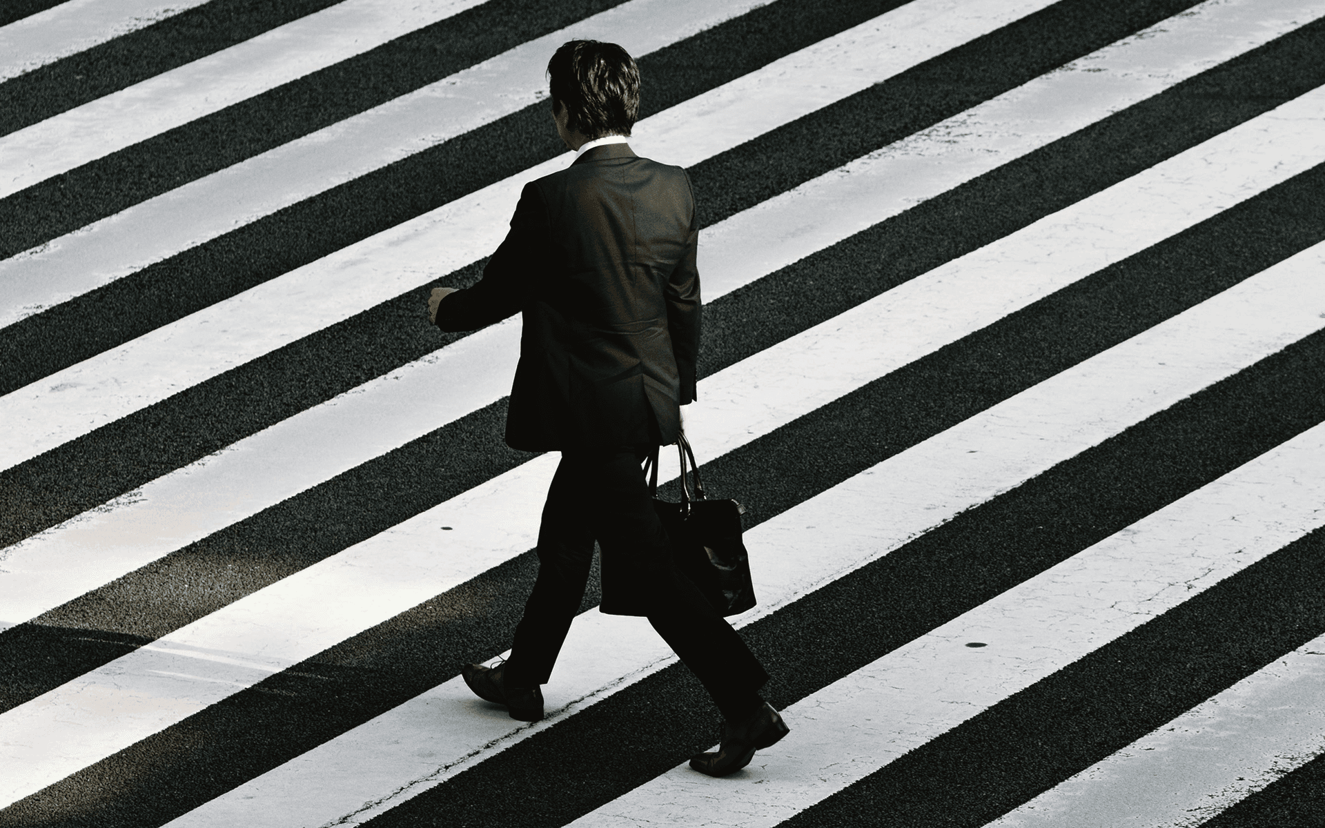 Businessman crossing a striped crosswalk