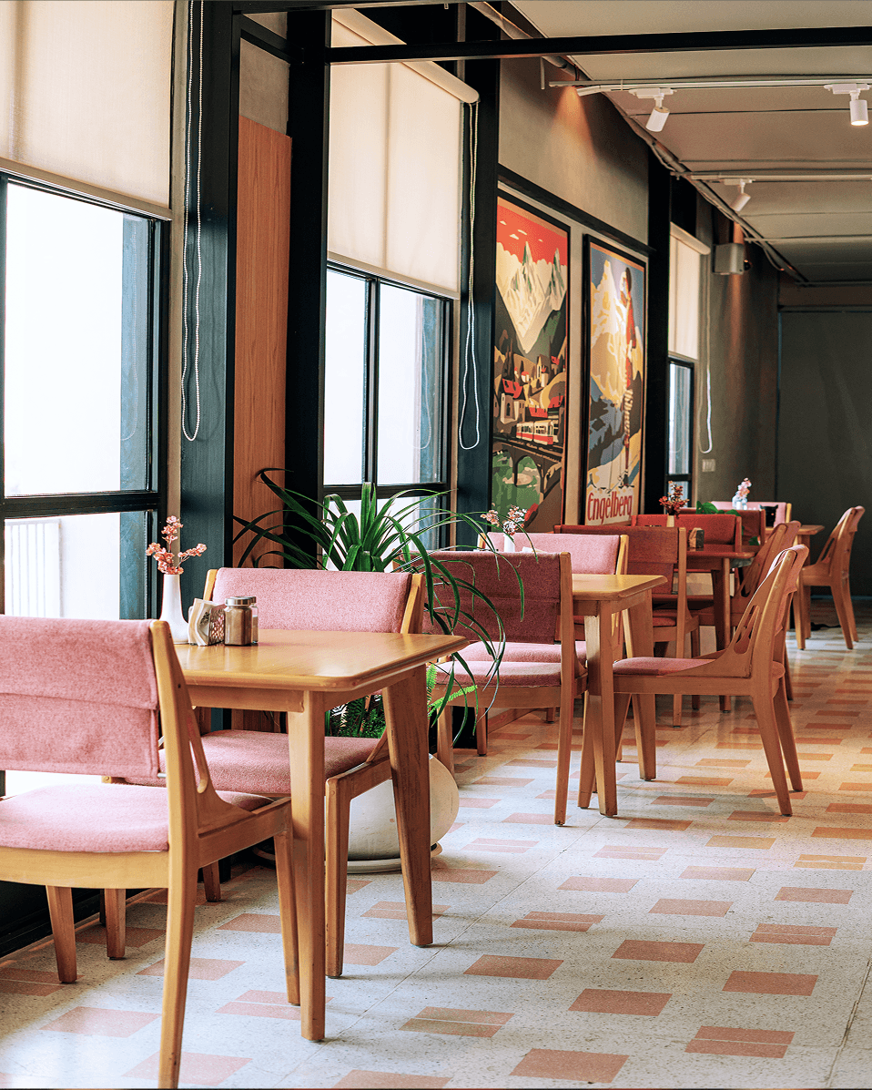 Alpirious restaurant with pink chairs and Swiss travel posters